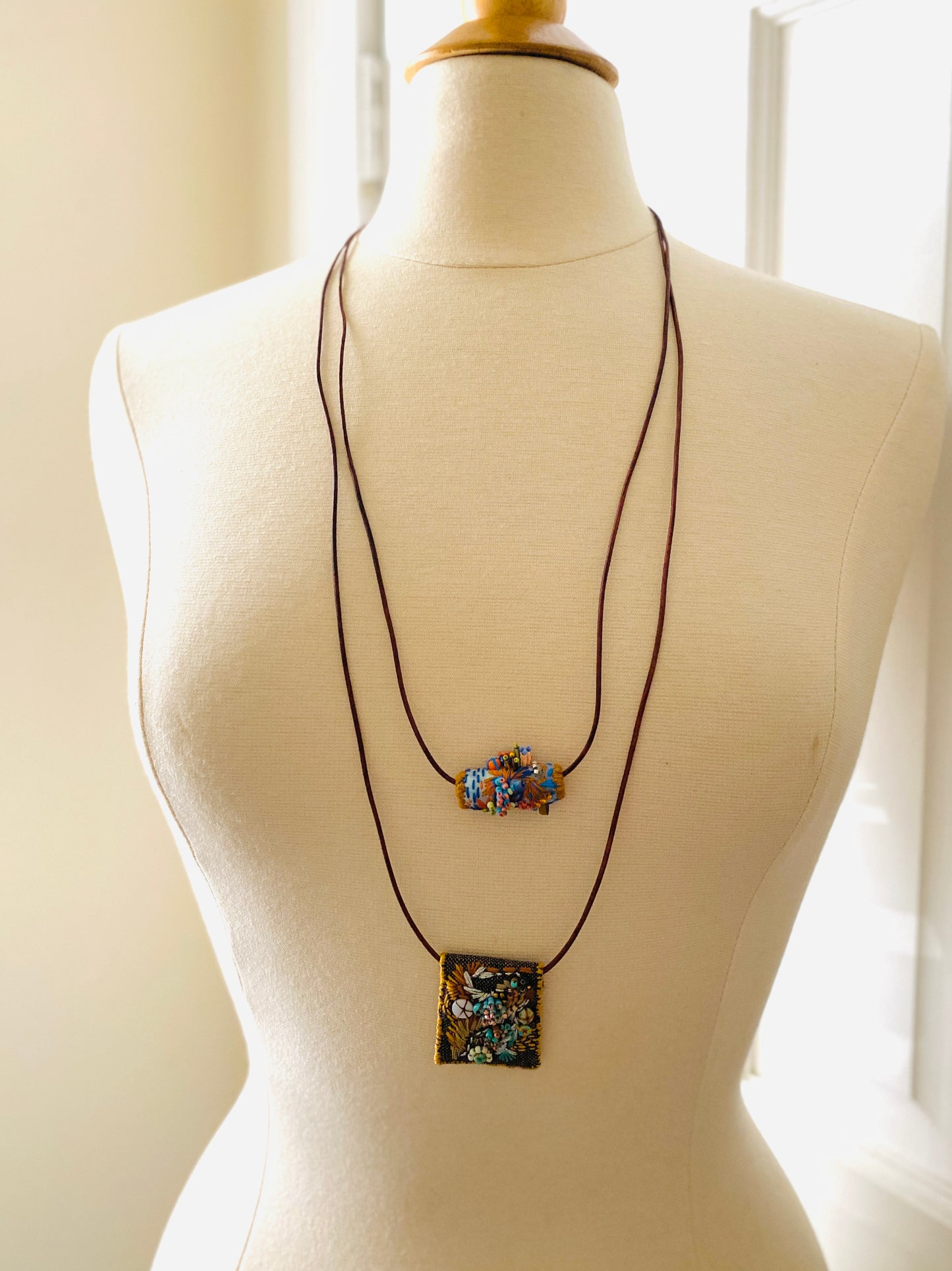 "Horizon" Blue and orange embroidered and beaded textile necklace.