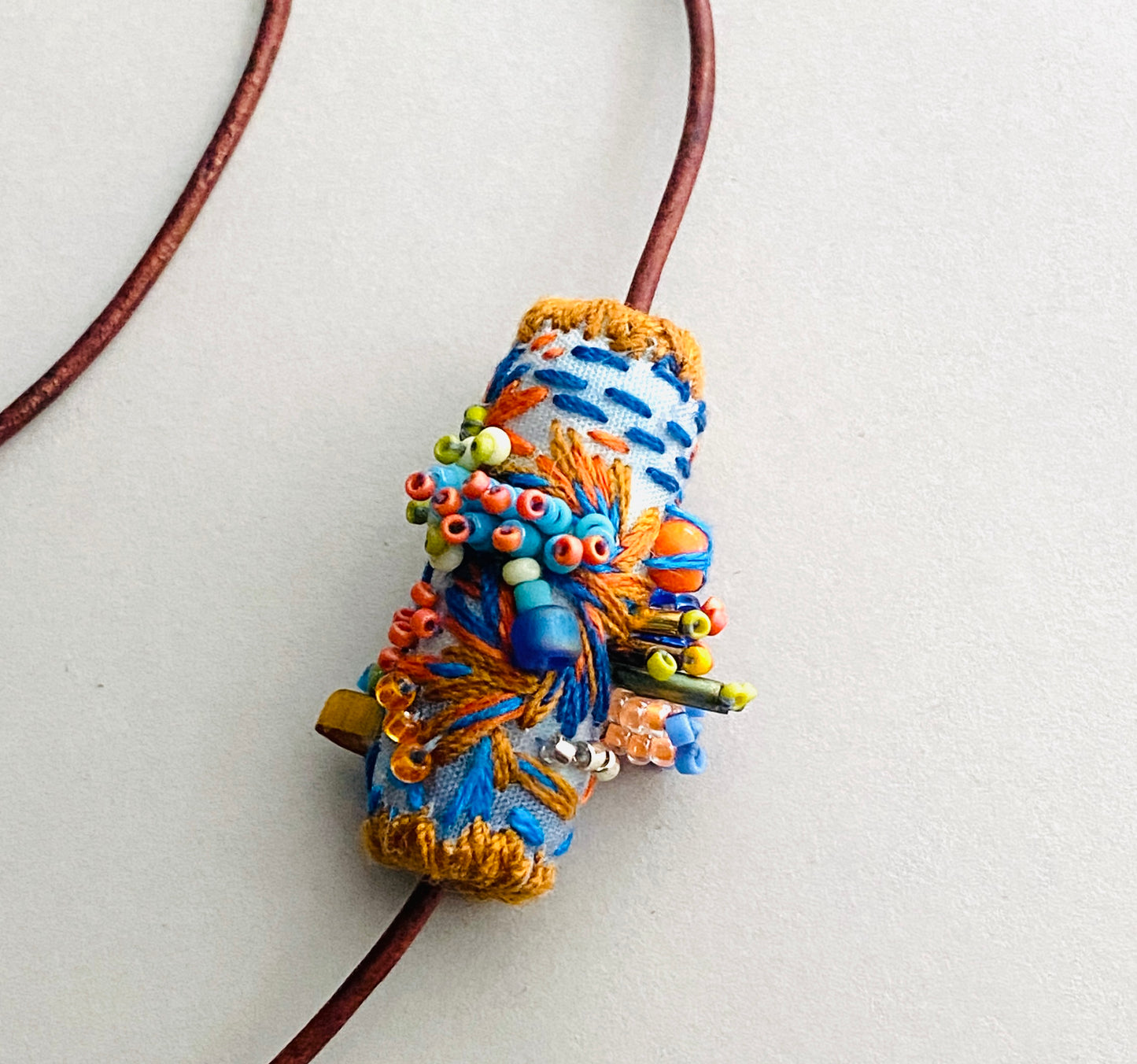 "Horizon" Blue and orange embroidered and beaded textile necklace.